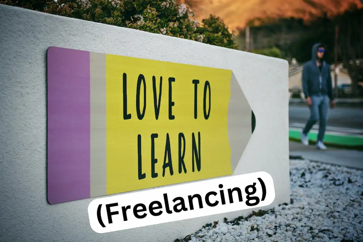Pencil painted on a wall that says "love to learn" with the word "freelancing" underneath in brackets.